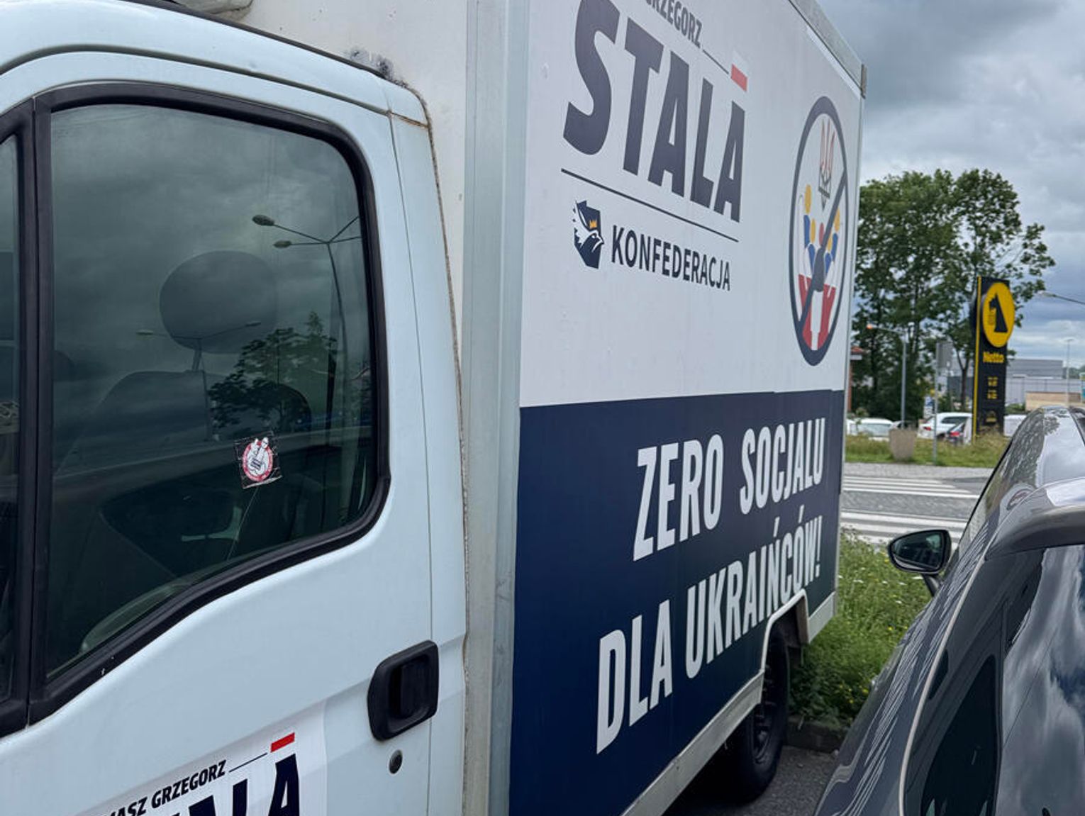 ANTY-UKRAIŃSKIE HASŁA DZIAŁACZA KONFEDERACJI. REKLAMOWY ZŁOM ZAJMUJE MIEJSCE PARKINGOWE